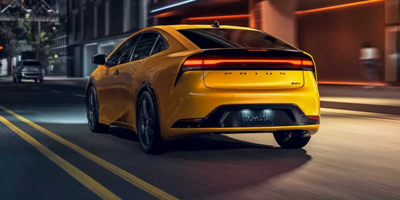 2027 Toyota Prius exterior driving view showing sleek aerodynamic roofline and 19-inch alloy wheels